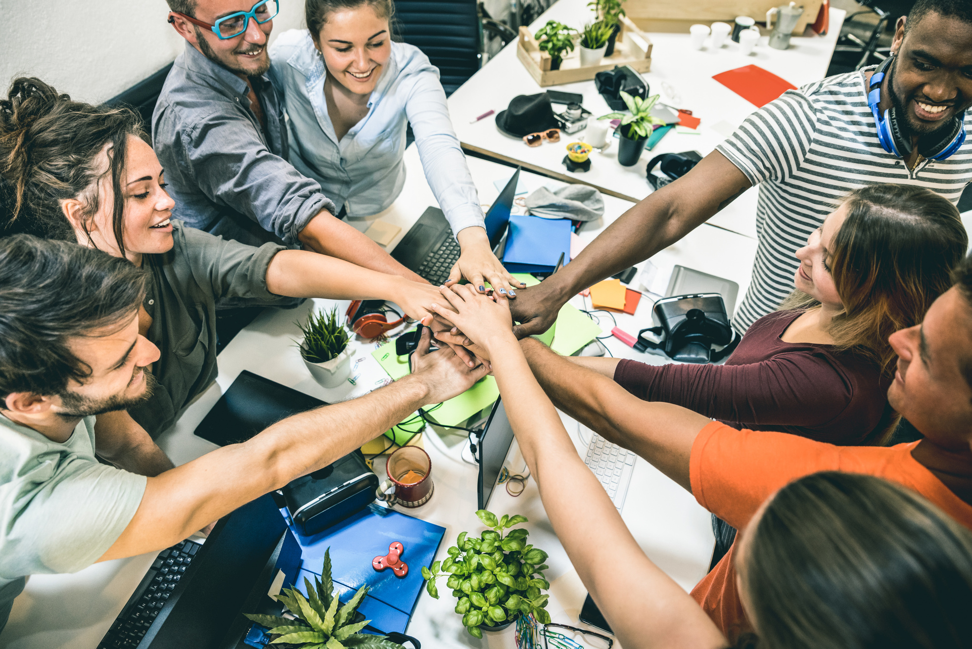 Young employee startup workers group stacking hands at urban studio during entrepreneurship brainstorming project - Business concept of human resources on working time - Start up internship at office